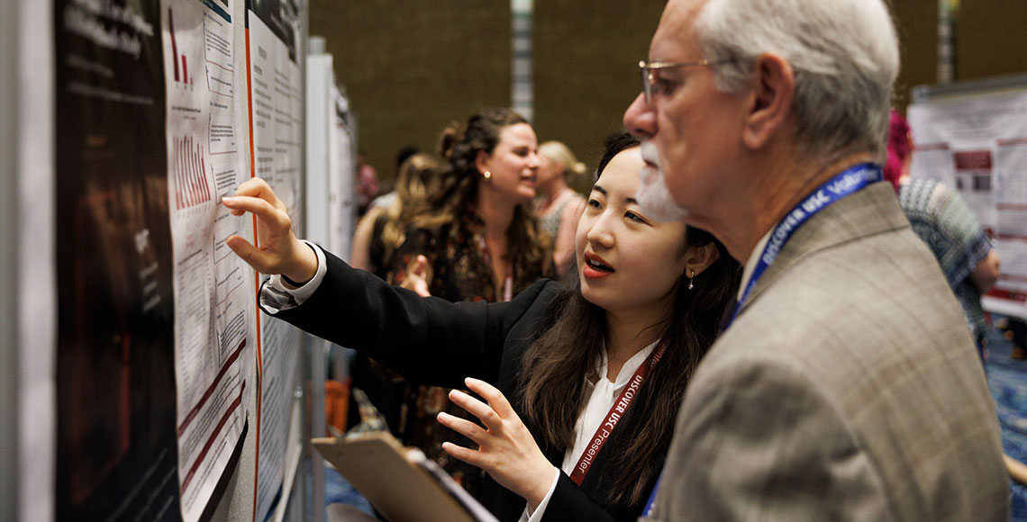 A graduate student presenter discusses her poster with a reviewer at Discover USC 2026.