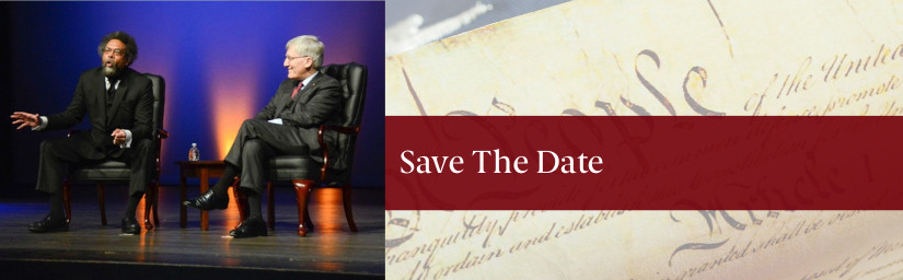 Card reads "save the date" features Two men sit in leather chairs, wearing suits, on an stage with ambient lighting 