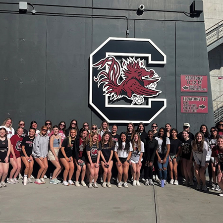 Members of the Women in Sport and Entertainment Club pose for a photo outside of Williams-Brice Stadium