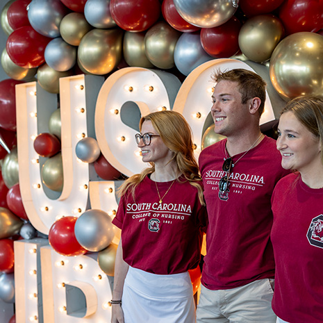 nursing students smiling while standing in front of a balloon display