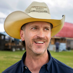 Alumnus Becker Hall wears a straw cowboy hat.